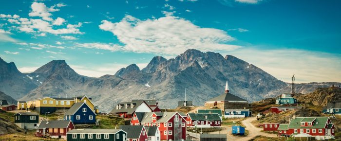 Small town on east coast of Greenland with colorful houses and m